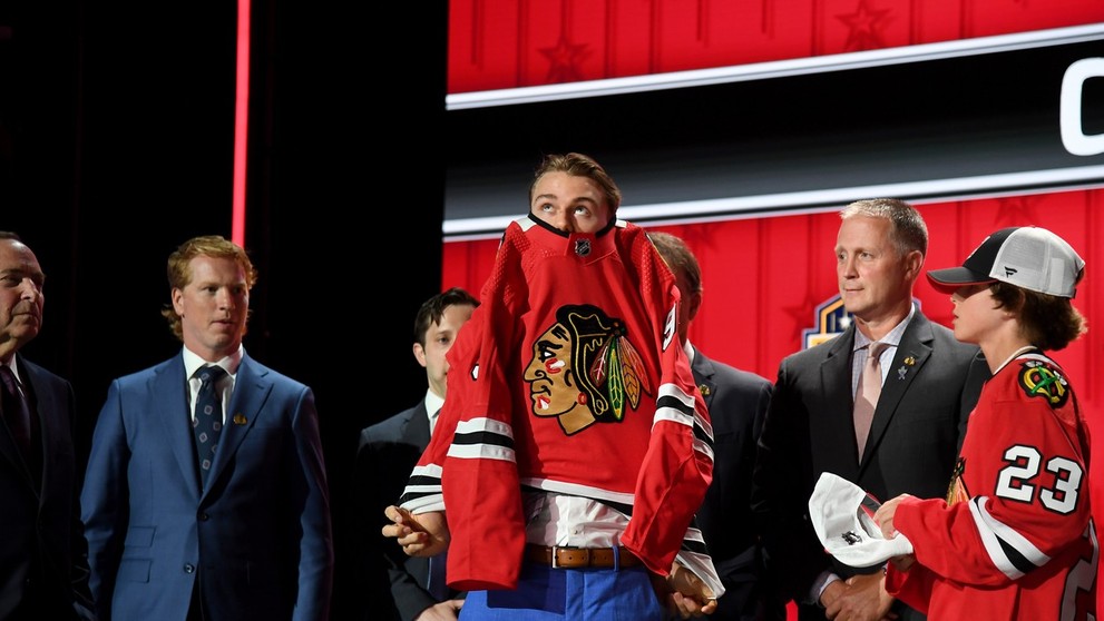 Connor Bedard si oblieka dres Chicaga.