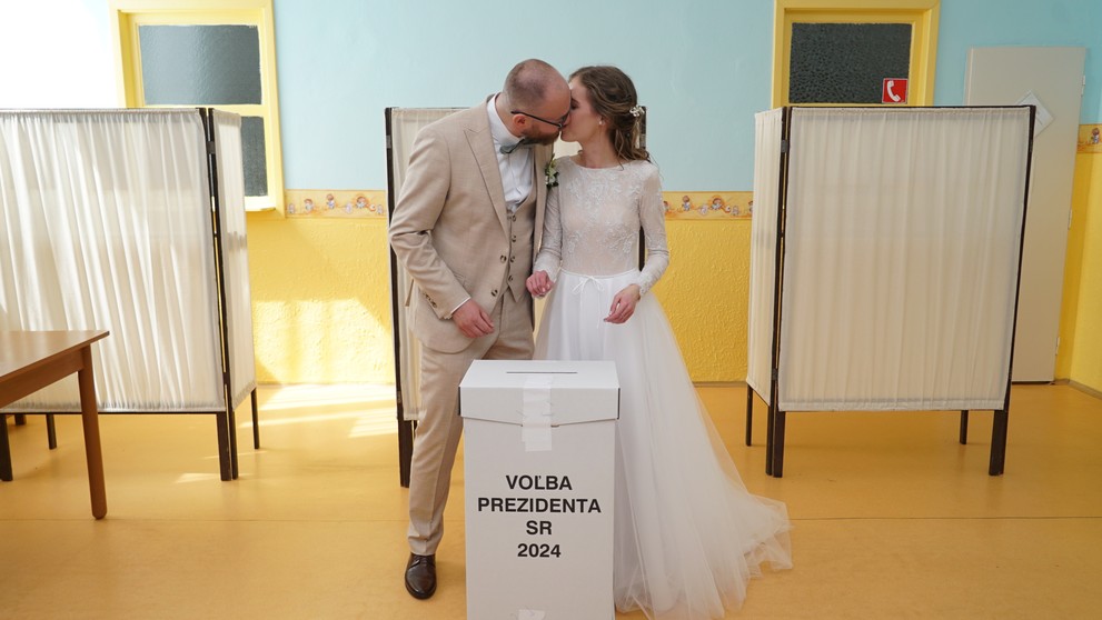 Ženích a nevesta sa bozkávajú po volebnom akte vo volebnej miestnosti počas druhého kola prezidentských volieb v Komárne.