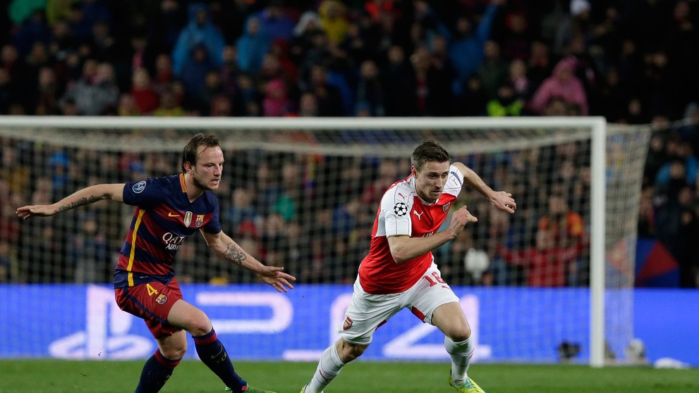 Súboj hráčov FC Barcelona Ivana Rakitiča a Arsenalu Londýn Nacha Monreala.