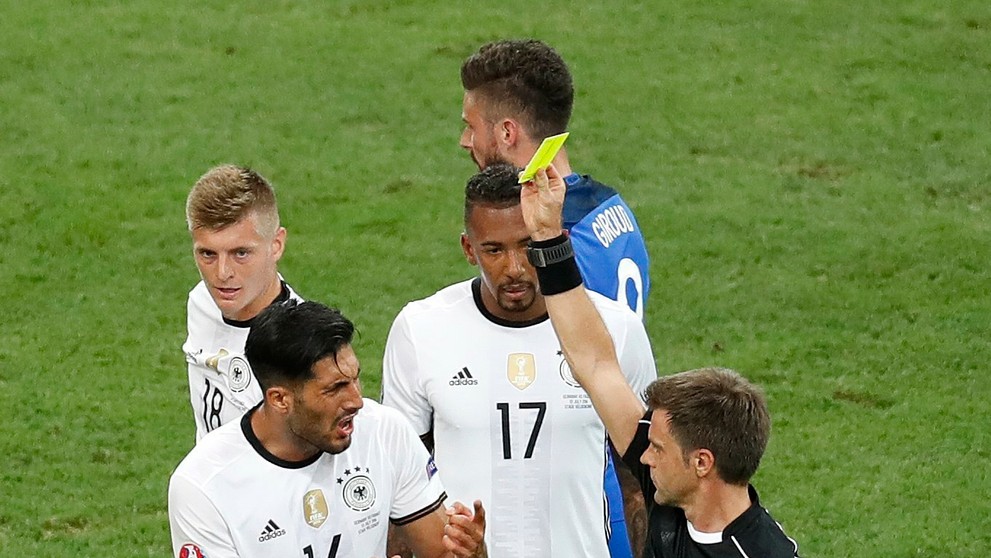 Rozhodca Nicola Rizzoli dáva žltú kartu Nemcovi Emre Canovi v semifinále ME proti Francúzsku.