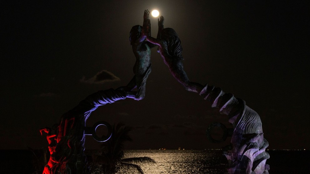 Turisti sledujú zatmenie Mesiaca v mexickom letovisku Parque Fundadores.