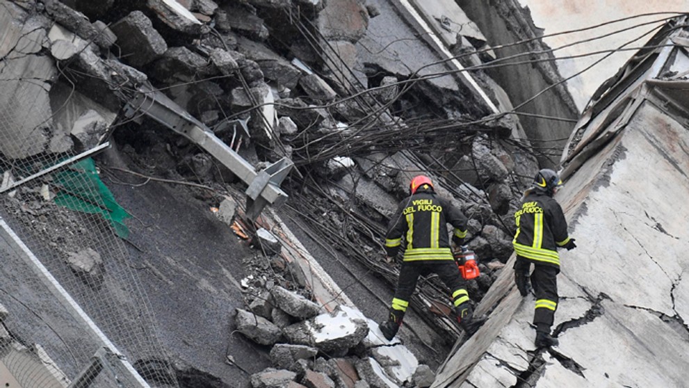 Hasiči prehliadajú sutiny pod zrúteným mostom Morandi v Janove.