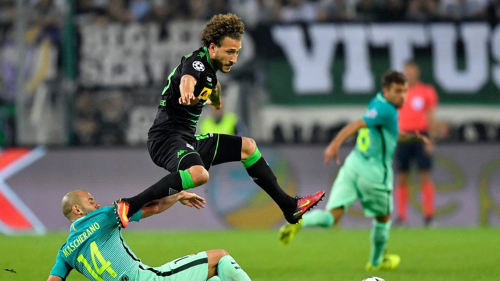 Vo výskoku hráč Borussie Mönchengladbach Fabian Johnson, na zemi v ostrom sklze defenzívna opora Barcelony Javier Mascherano v d