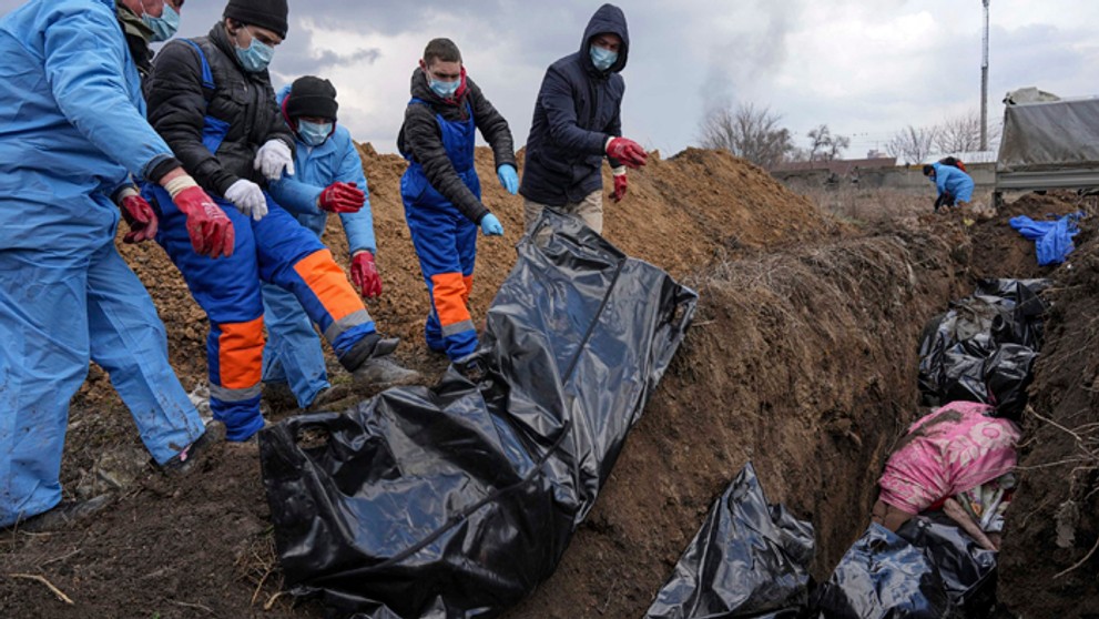 Mŕtve telá ukladujú do masového hrobu v Mariupole.