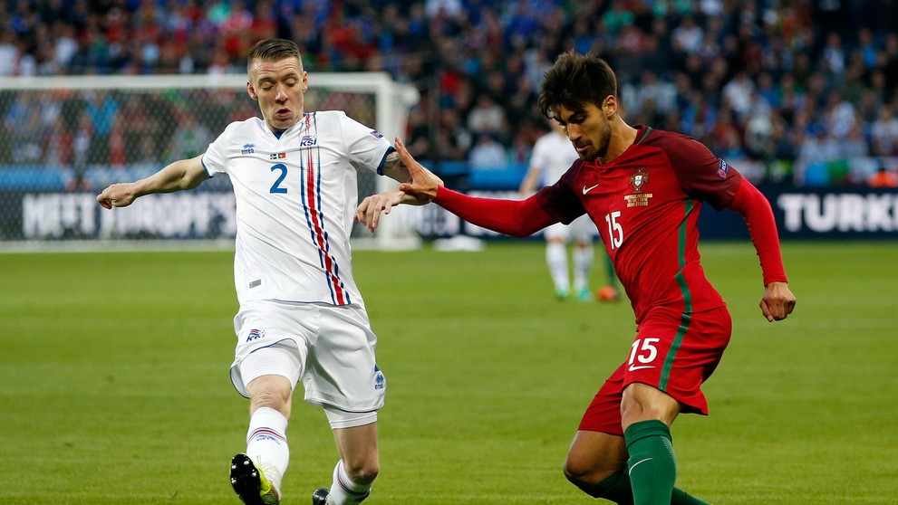 Portulčan Andre Gomes (vpravo) v obkľúčení Islanďana Birkira Saevarssona vo vzájomnom dueli na ME vo Francúzsku.