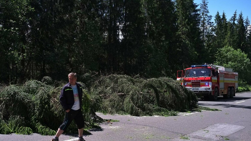 Na snímke hasiči a dobrovoľní hasiči zo Ždiaru odpratávajú popadané stromy z cesty