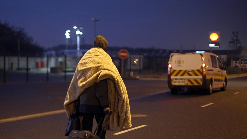 Migrant s batožinou opúšťa utečenecký tábor v severofrancúzskom prístavnom meste Calais, ktorý prezývajú Džungľa.