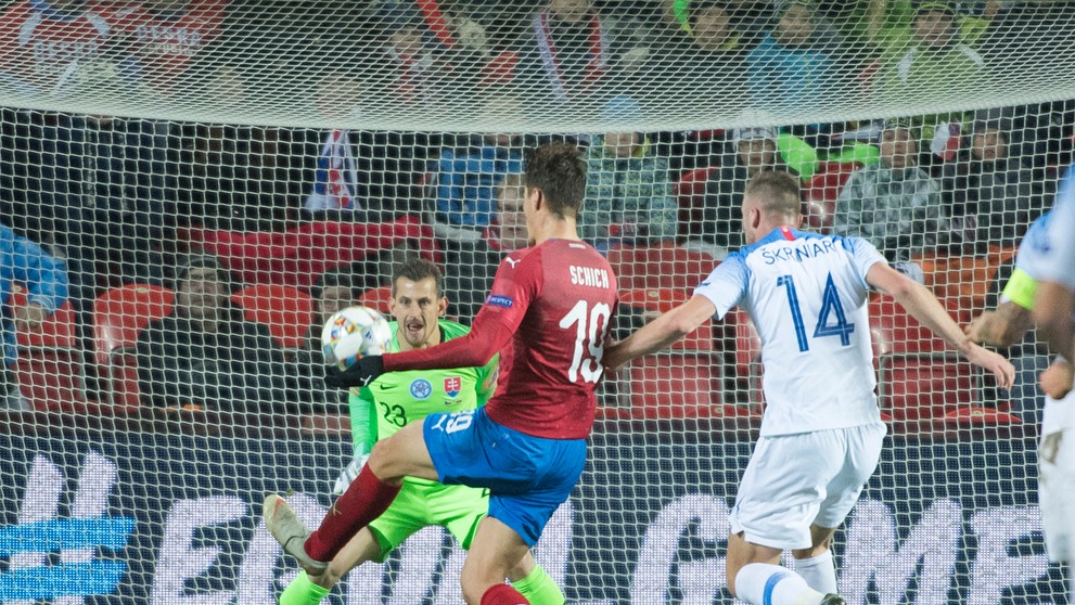 Vľavo slovenský brankár Martin Dúbravka, vpravo obranca Milan Škriniar, uprostred český útočník Patrik Schick strieľa gól.