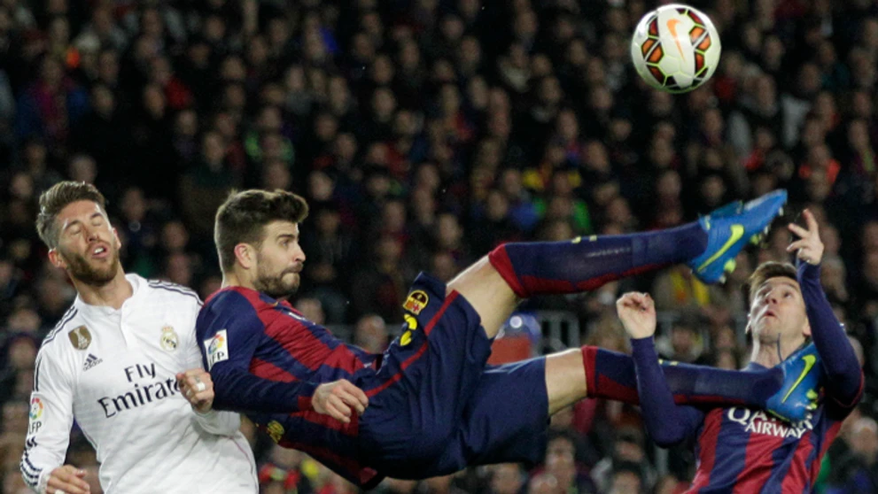 Gerard Pique a Lionel Messi (Barcelon) v akcii so Sergiom Ramosom (Real Madrid) počas  El Clásico.