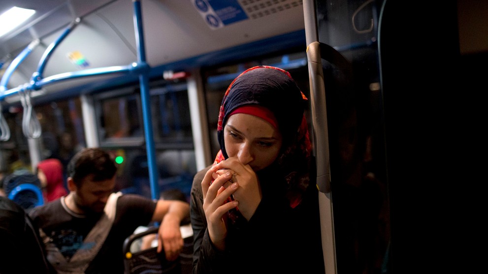 Žena čaká v autobuse, ktorý ju má odviesť z Maďarsko do Rakúska.