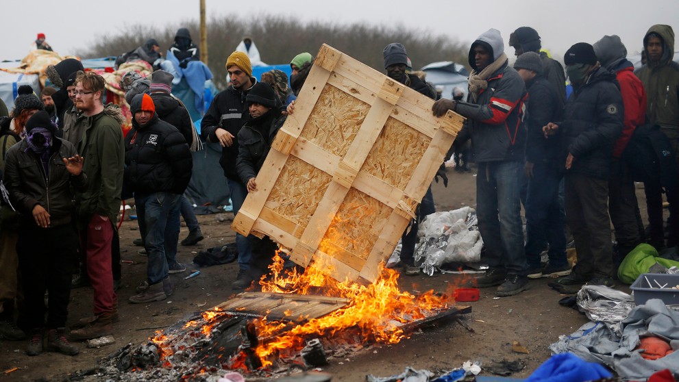Migranti v tábore pri Calais protestujú na strechách búd.