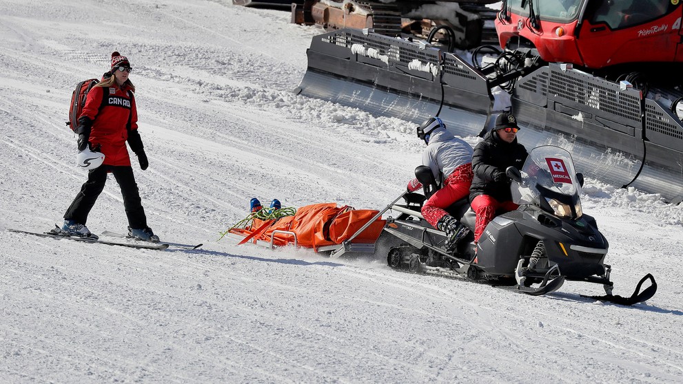 Záchranári prevážajú zraneného kanadského lyžiaraka Christophera Delbosca.