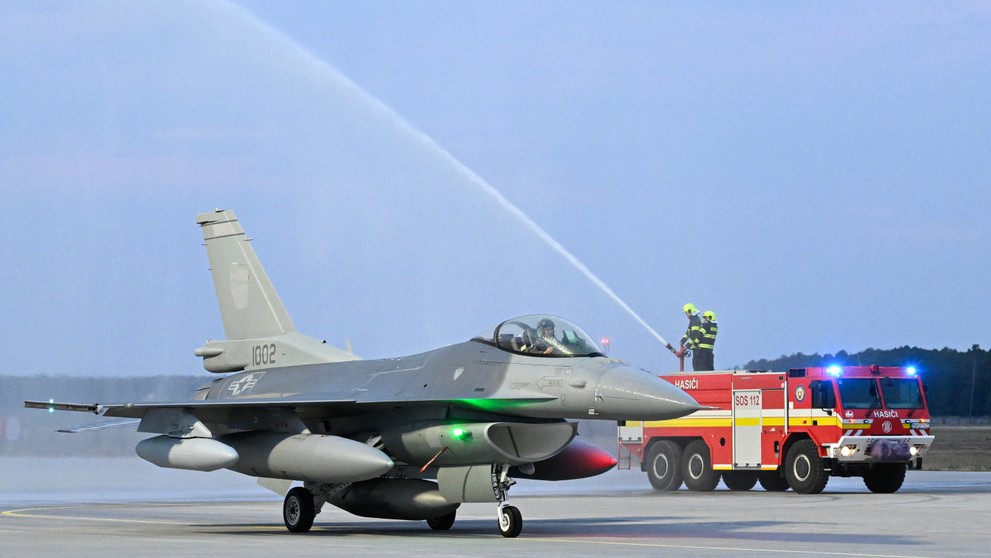 Jedna z dvoch stíhačiek F-16 symbolicky prechádza tzv. slávobránou z hasičských striekačiek v priestoroch Leteckej základne Malacky-Kuchyňa.