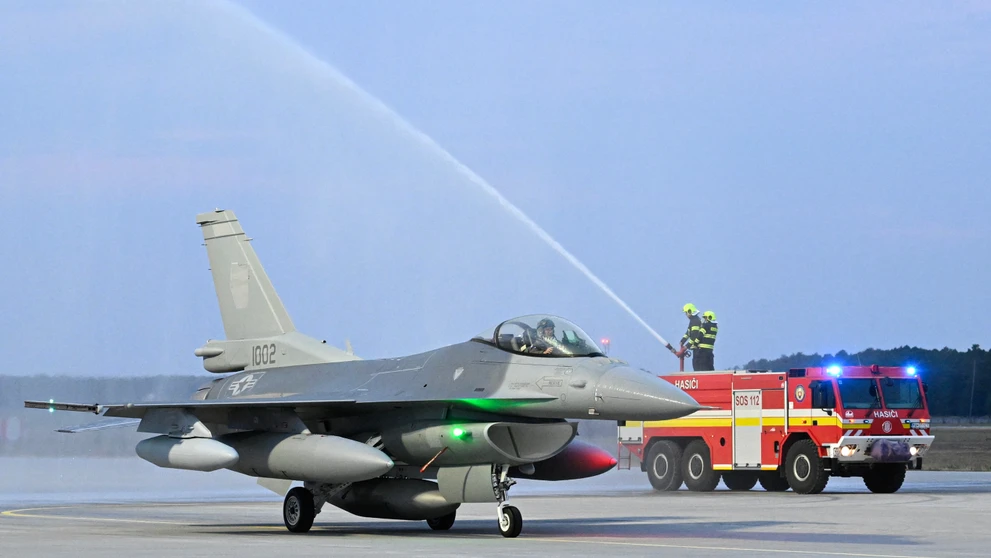 Jedna z dvoch stíhačiek F-16 symbolicky prechádza tzv. slávobránou z hasičských striekačiek v priestoroch Leteckej základne Malacky-Kuchyňa.