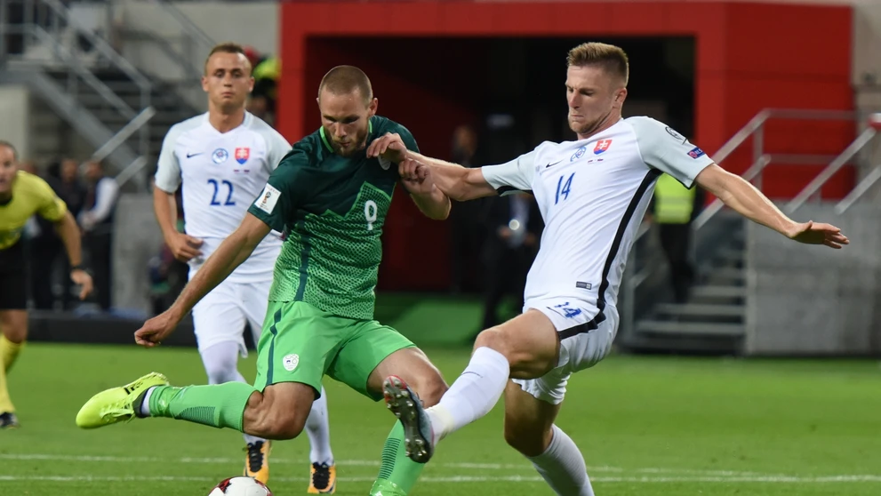 Na snímke vpravo hráč Slovenska Milan Škriniar a hráč Slovinska Tim Matavž v zápase kvalifikácie MS.