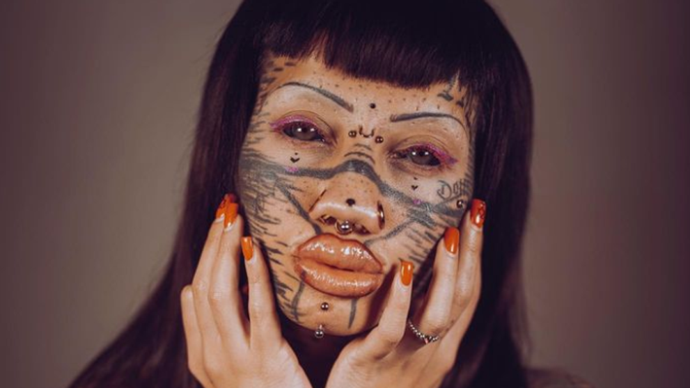 Tvár má plnú piercingov a tetovaní