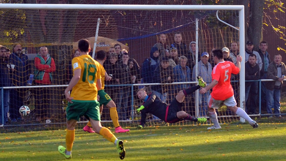 Druhý vľavo hráč MŠK Žilina Filip Hlohovský strieľa prvý gól brankárovi TJ FK Vyšné Opátske Igorovi Hajovskému.