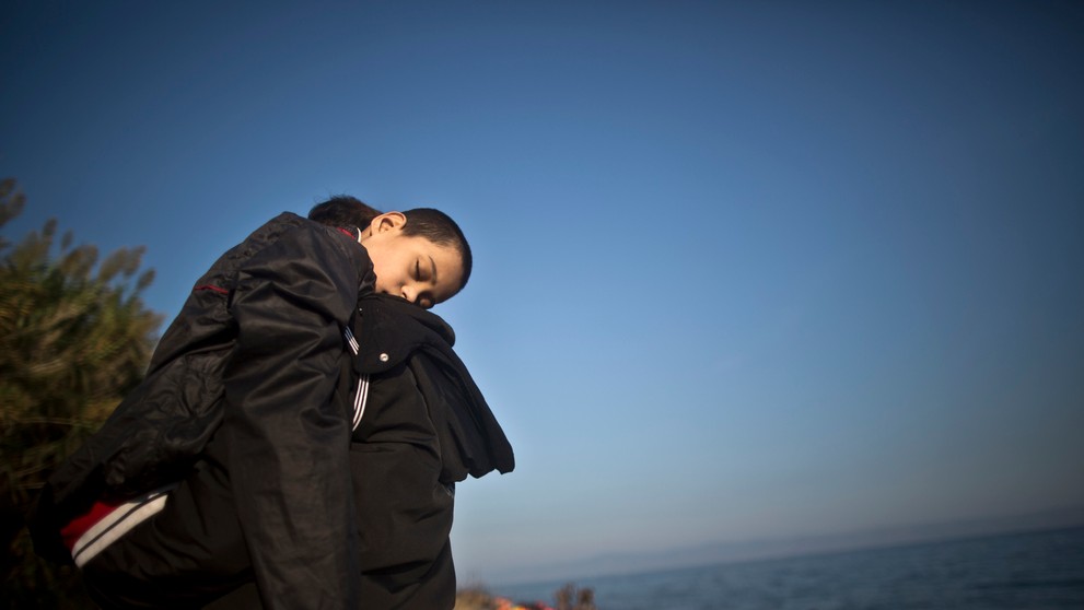 Utečenec nesie na rukách svojho syna