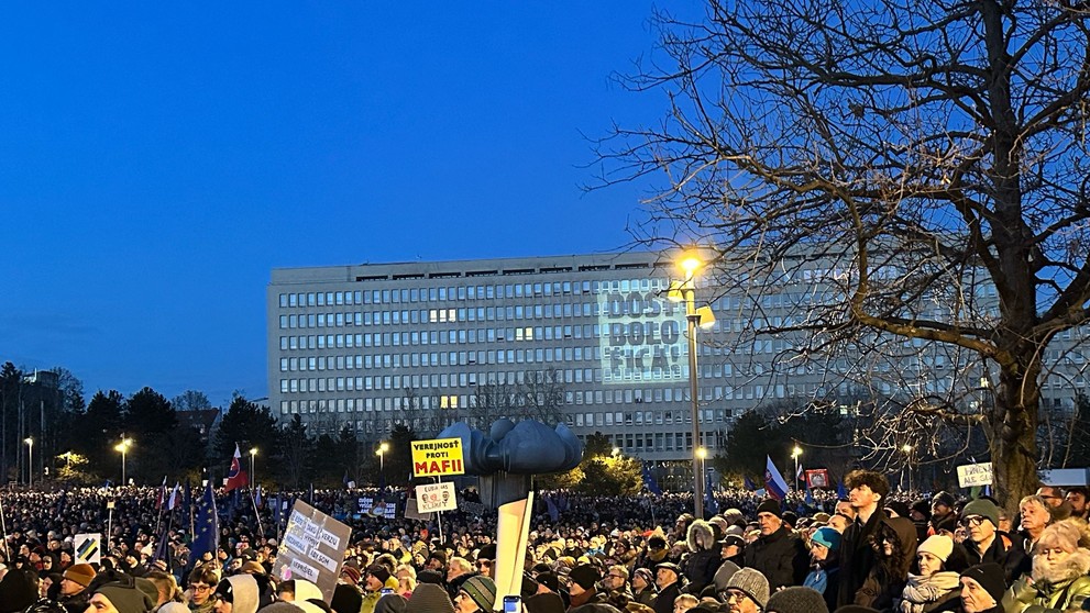 Protestujúci s nápisom projektovaným na budove