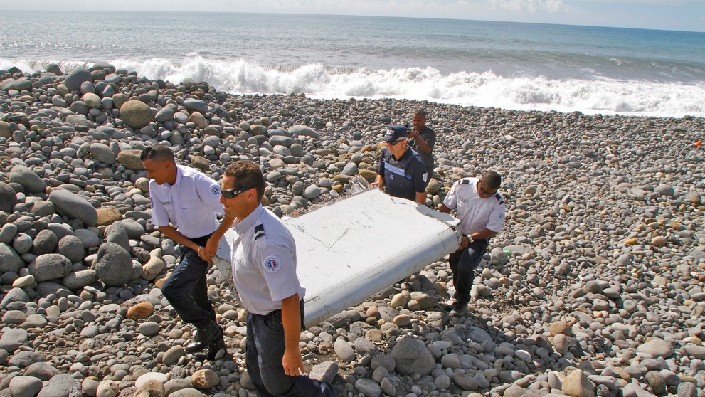 Policajti nesú časť lietadla v meste Saint-André na ostrove Réunion patriaceho k Francúzsku. 29. júla 