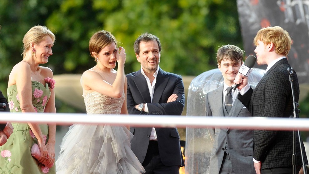 J. K. Rowlingová, Emma Watsonová a Daniel Radcliffe počúvajú príhovor Ruperta Grinta počas premiéry filmu Harry Potter a Dary smrti - 2.