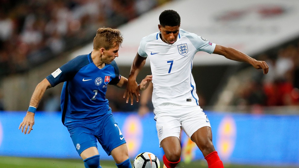Angličan Marcus Rashford (vpravo) uniká s loptou v zápase kvalifikácie MS, prizerá sa Peter Pekarík.