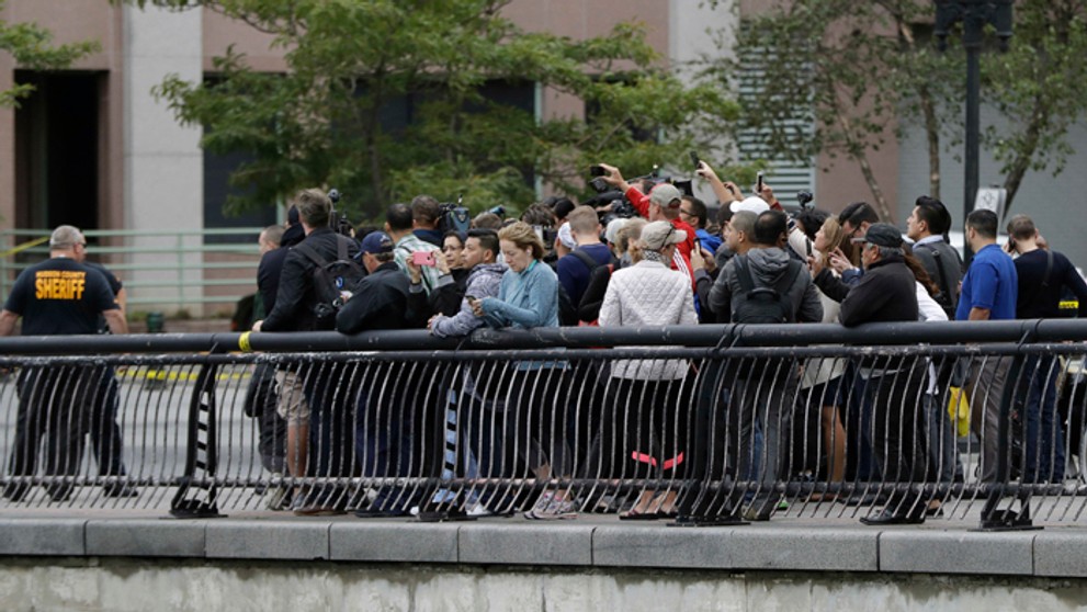 Zvedavci si fotia na mobilné telefóny miesto vykoľajenia vlaku v Hobokene v New Jersey.