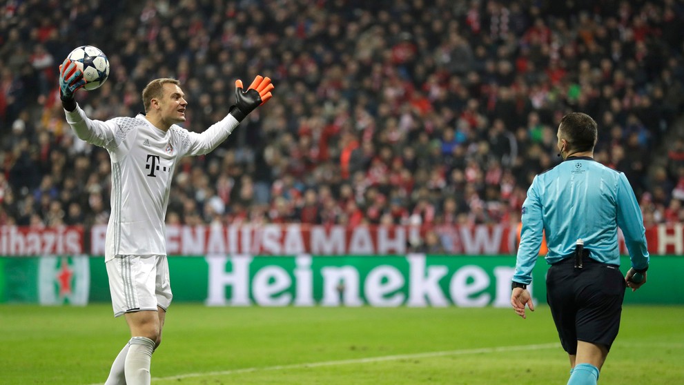 Gólman Bayernu Manuel Neuer debatuje s čiarovým arbitrom po odpískaní pokutového kopu v osemfinále LM proti Arsenalu.