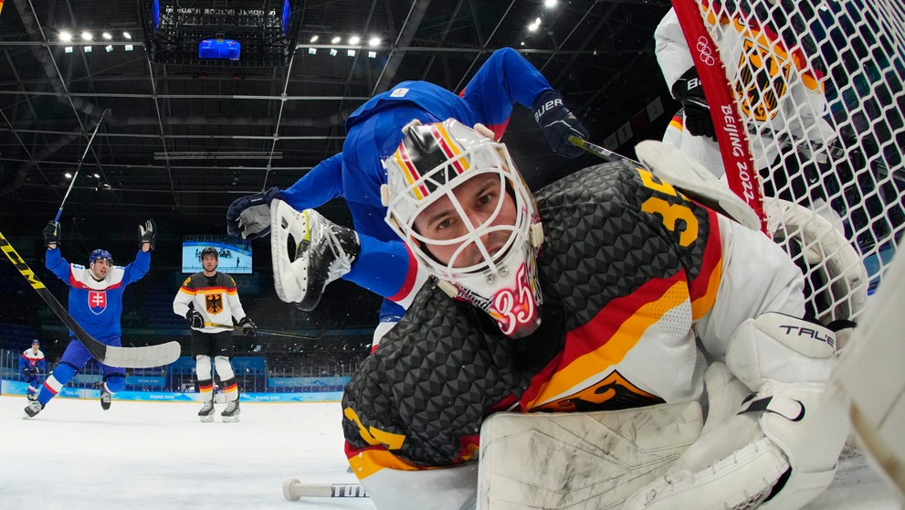 Nemecký brankár Mathias Niederberger v kolízii s Tomášom Jurčom v kvalifikačnom stretnutí ZOH 2022.