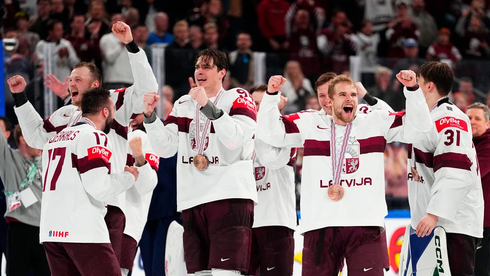 Lotyšskí hokejisti oslavujú zisk medaily
