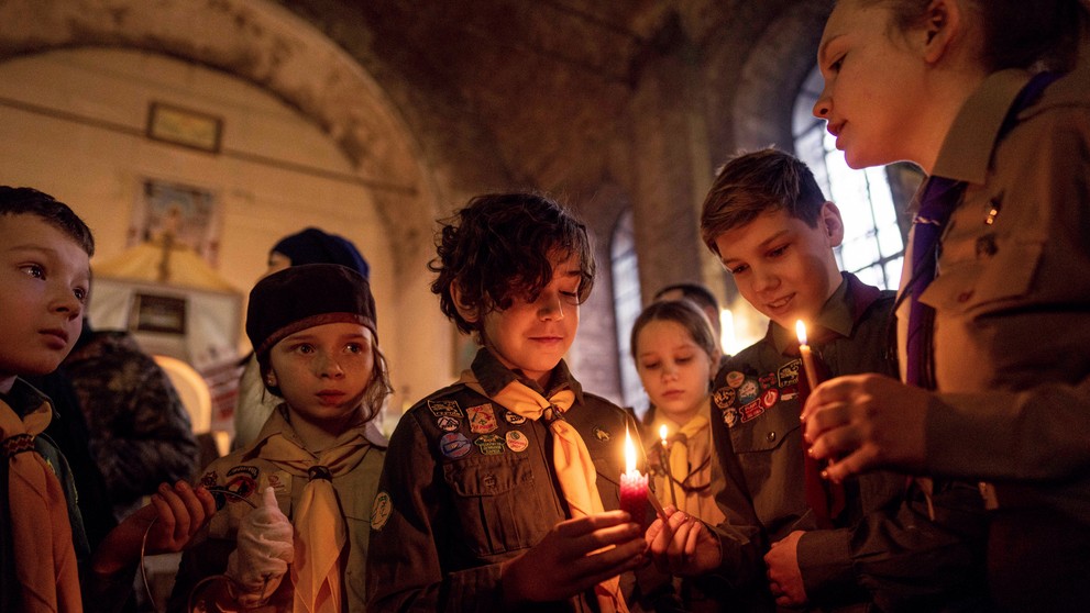 Ukrajinskí skauti s betlehemským svetlom počas vianočnej omše v Charkove.