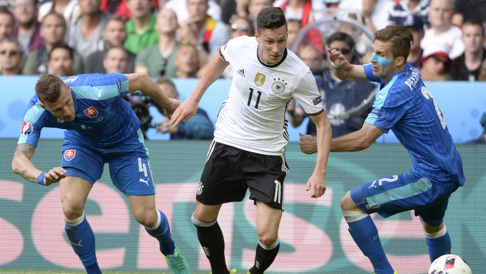 Na snímke uprostred Julian Draxler (Nemecko) a hráči Slovenska Ján Ďurica (vľavo) a Peter Pekarík na ME.