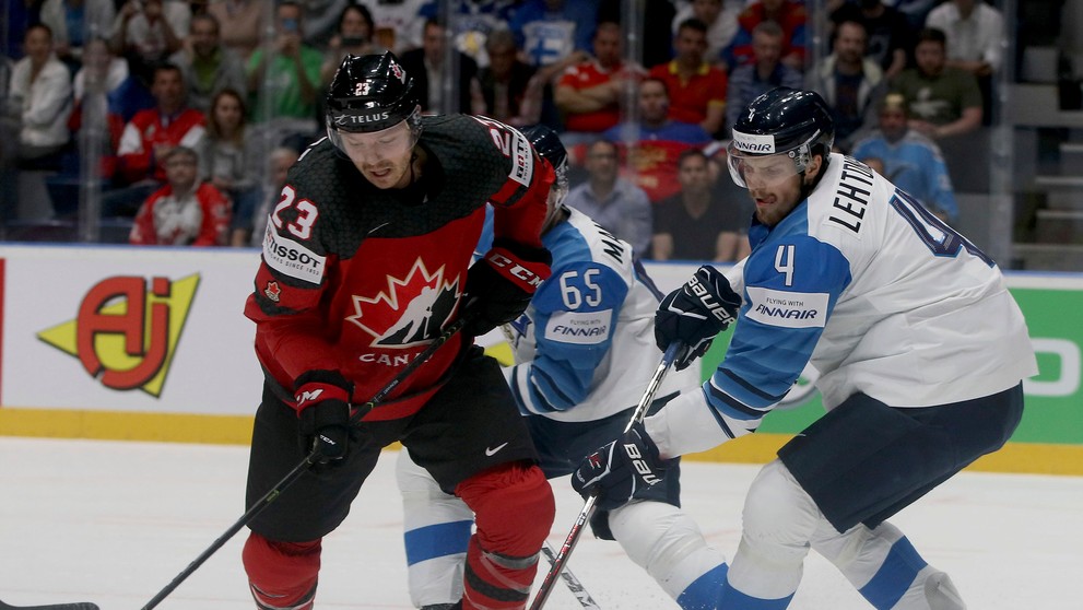 Fín Joel Kiviranta (v strede) v obkľúčení Kanaďanov vľavo Anthony Mantha a Kyle Turris vo finále MS 2019.