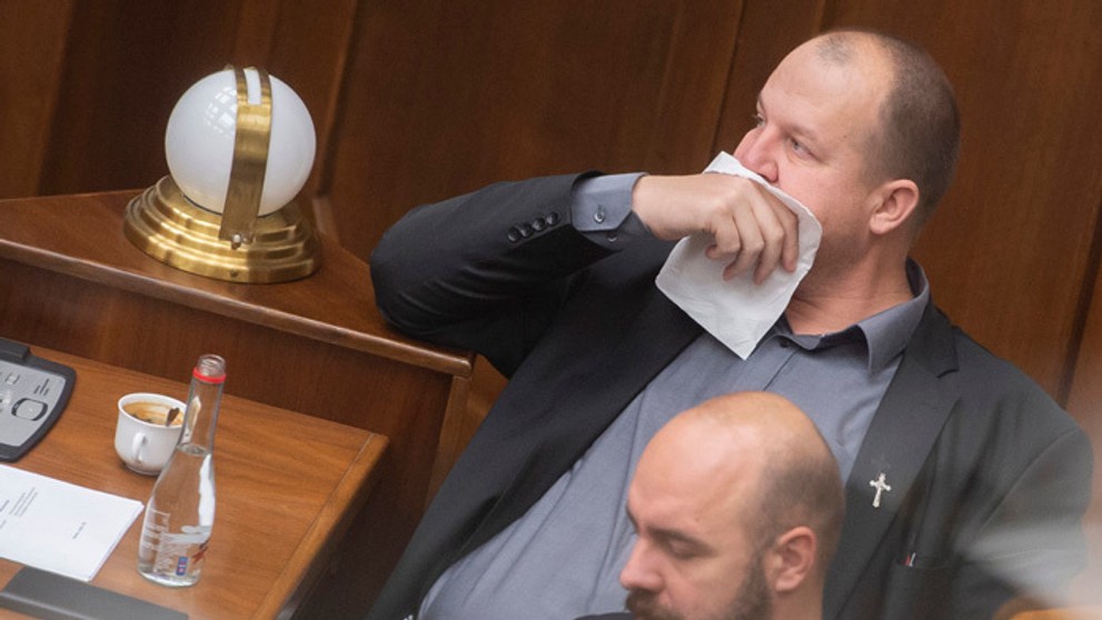 Peter Krupa si prekrýva tvár papierovou vreckovkou a dole Andrej Medvecký (obaja ĽSNS).