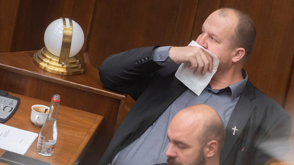 Peter Krupa si prekrýva tvár papierovou vreckovkou a dole Andrej Medvecký (obaja ĽSNS).