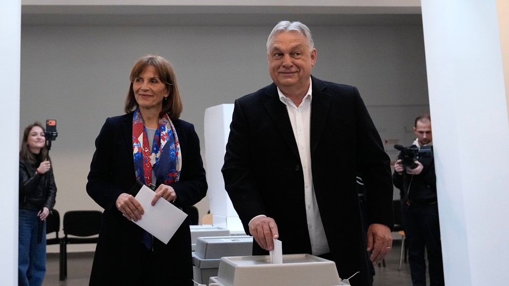 Viktor Orbán vhadzuje svoj hlasovací lístok do volebnej schránky vedľa svojej družky.