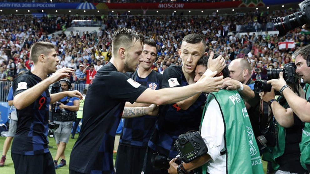 Chorvátski futbalisti utešujú fotografa, ktorého v eufórii zvalili po víťaznom góle na zem.