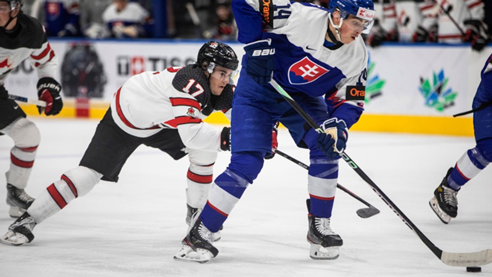 Slovenský hokejista Maroš Jedlička (vpravo) korčuľuje s pukom.