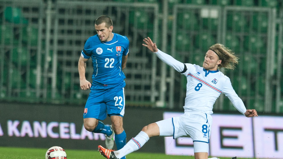 Na snímke vľavo Viktor Pečovský (Slovensko) a vpravo Birkir Bjarnason (Island) na archívnej snímke počas prípravného duelu.