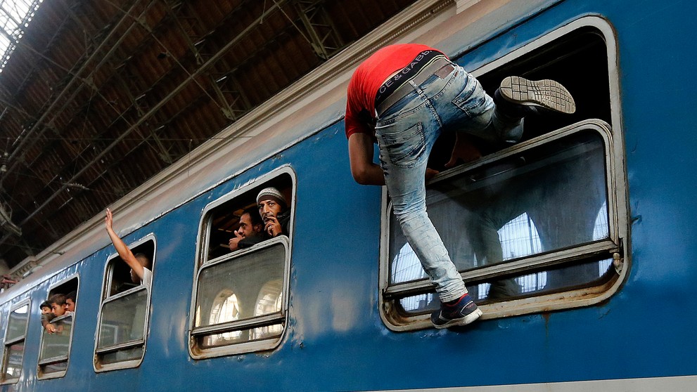 Migranti sa snažia nastúpiť do vlaku v Budapešti.