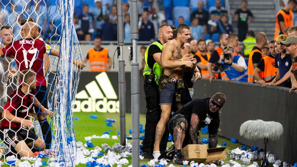 Na snímke vpravo jeden z fanúšikov Slovana vbehol na ihrisko a pridal sa k roztržke hráčov oboch mužstiev.