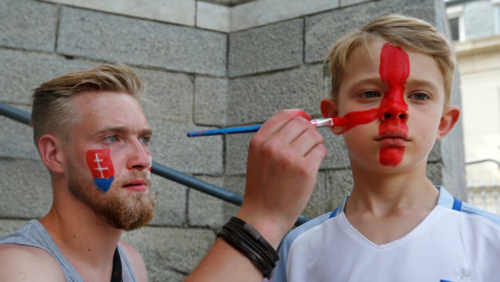 Muž na ulici maľuje malého fanúšika Anglicka.