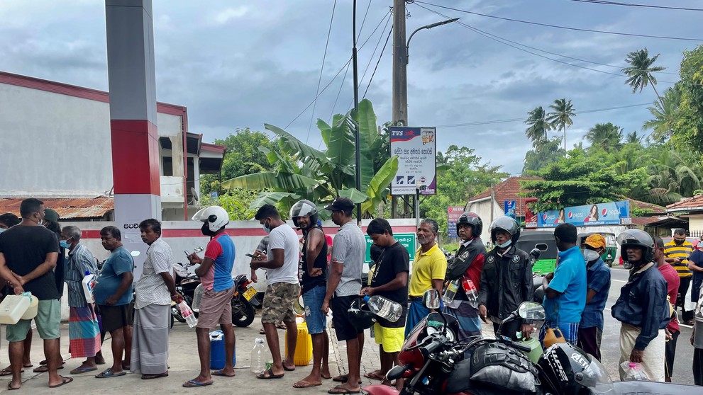 Ľudia čakajúci na benzín s fľaškami v ruke 