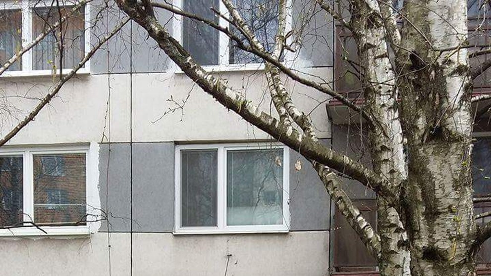 Mládenci v Leviciach oblievajú dievča pred panelákom.