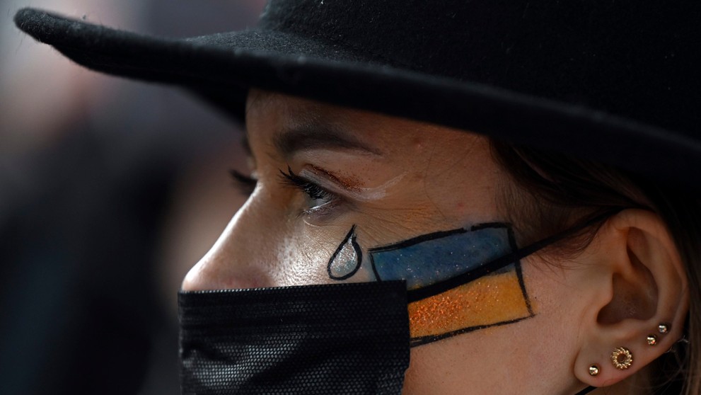 Ukrajinka si nakreslila na tvár vlajku a slzu