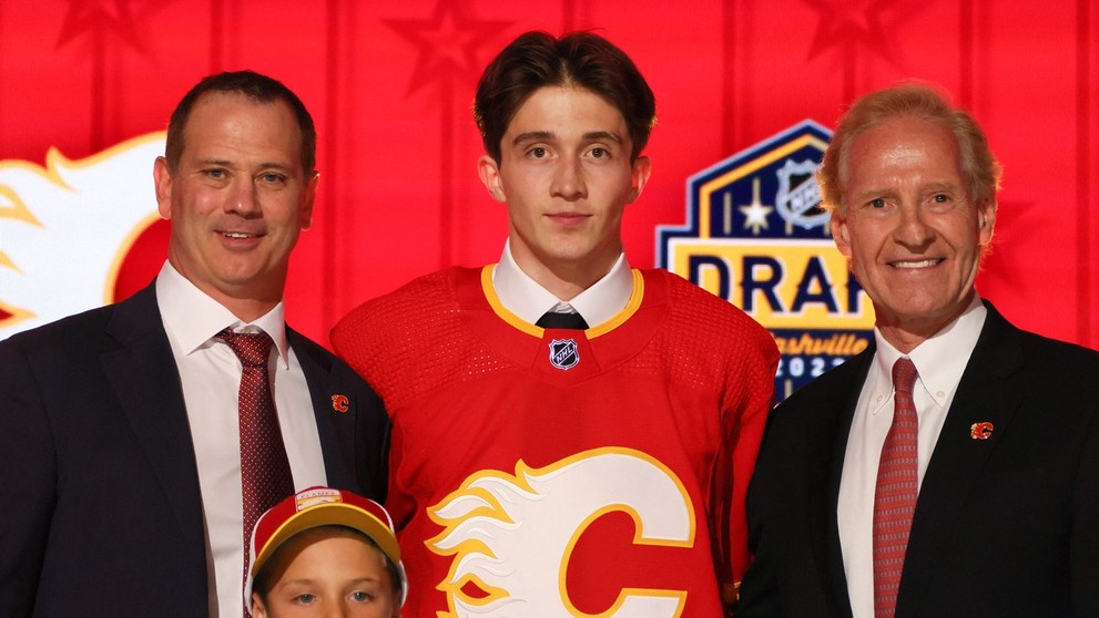 Samuel Honzek pózuje v drese Calgary na NHL drafte 2023.