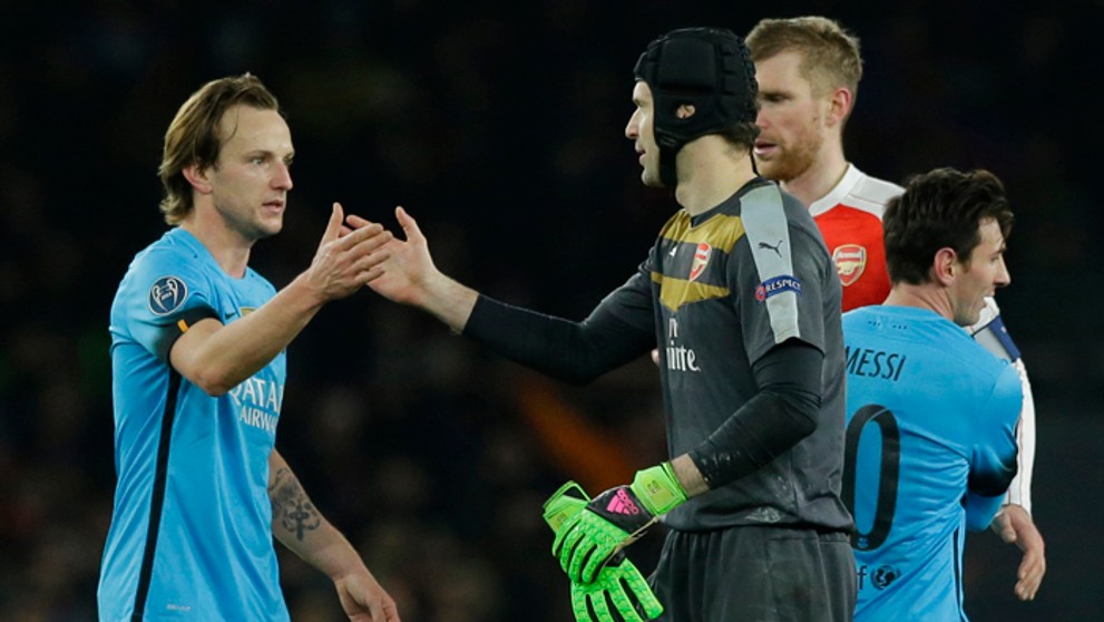 Brankár Arsenalu Petr Čech si podáva ruku s Ivom Rakitičom, v pozadí Lionel Messi.