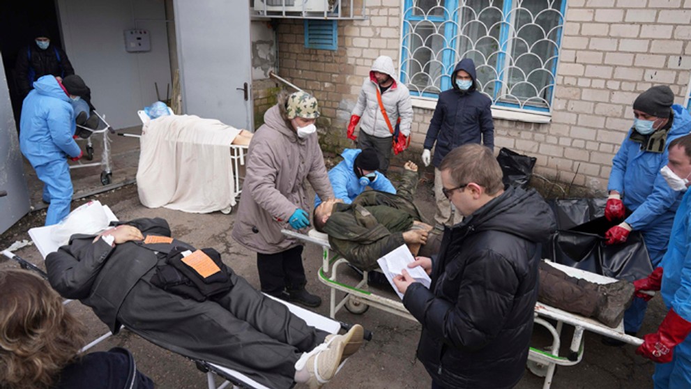 Telá obetí, ktoré budú dávať do vriec a ukladať do masového hrobu  v Mariupole.