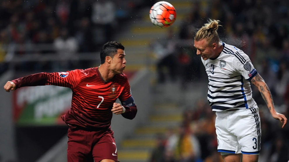 Portugalský reprezentant Cristiano Ronaldo súperí s Dánom Simonom Kjaerom v kvalifikácii na ME 2016.