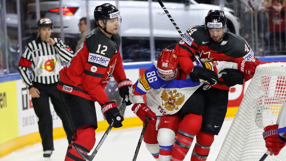 Dvojica Kanaďanov Colton Parayko (vľavo) a Marc-Edouard Vlasic atakuje v semifinále MS 2017 Rusa Nikitu Kučerova (v strede).